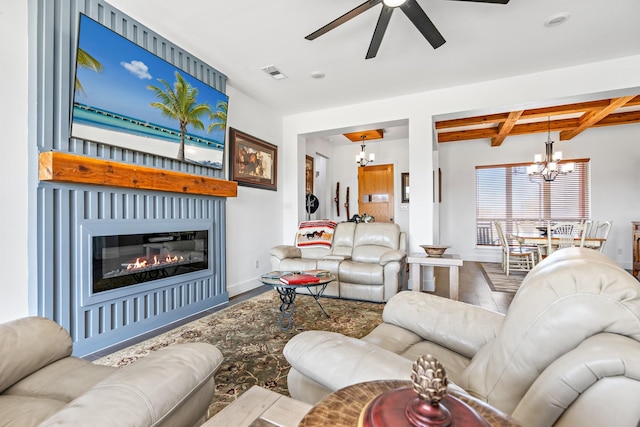 living area with beam ceiling, visible vents, baseboards, wood finished floors, and ceiling fan with notable chandelier