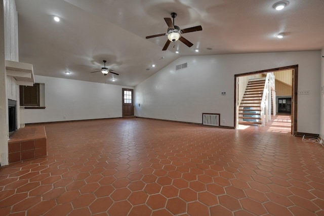 unfurnished living room with tile patterned floors, vaulted ceiling, a fireplace, visible vents, and a ceiling fan