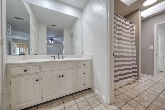 bathroom with a shower with curtain, vanity, a ceiling fan, a textured wall, and tile patterned flooring
