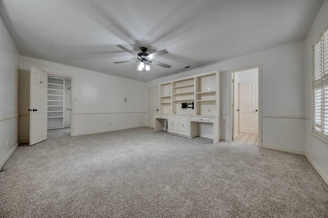 unfurnished living room featuring light colored carpet, visible vents, a ceiling fan, and baseboards
