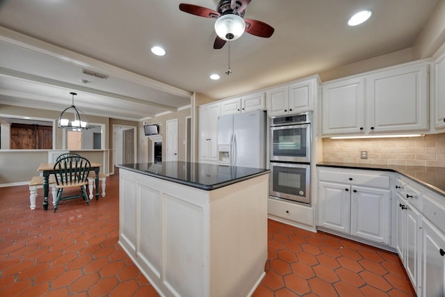 kitchen featuring double oven, white cabinetry, decorative backsplash, dark countertops, and visible vents
