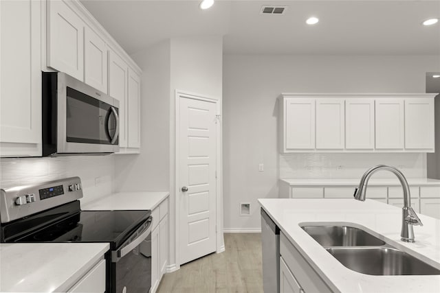 3246 Baehr, Royse City, TX 75189 - kitchen with stainless steel appliances, white cabinetry, light wood-style flooring, recessed lighting, and backsplash