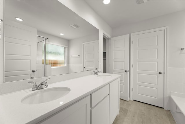 3246 Baehr, Royse City, TX 75189 - bathroom featuring double vanity, wood finished floors, a bathtub, recessed lighting, and a shower