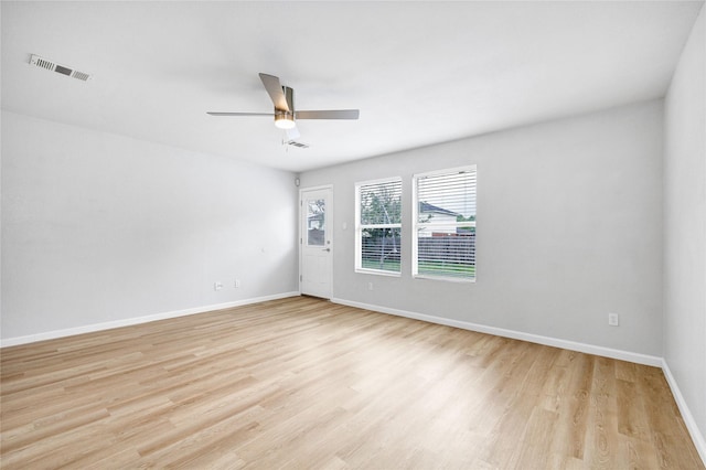 unfurnished room featuring baseboards, visible vents, ceiling fan, and light wood finished floors
