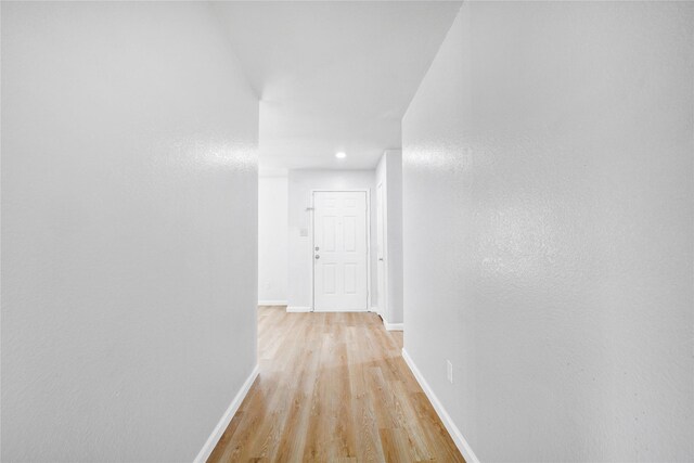 hall featuring recessed lighting, light wood-style flooring, and baseboards