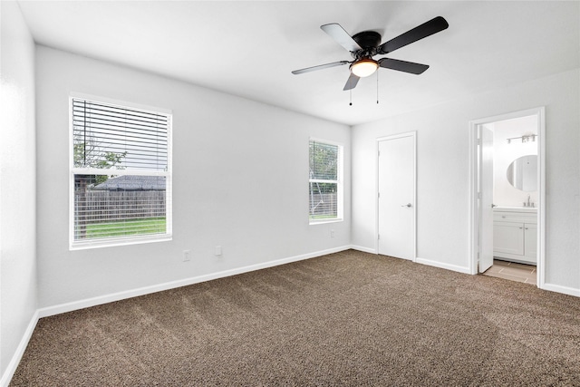 unfurnished bedroom featuring ceiling fan, connected bathroom, carpet flooring, and baseboards