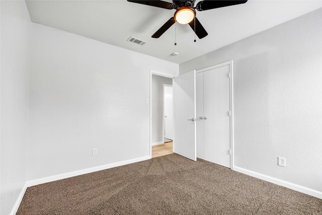 unfurnished bedroom with carpet flooring, a closet, ceiling fan, visible vents, and baseboards