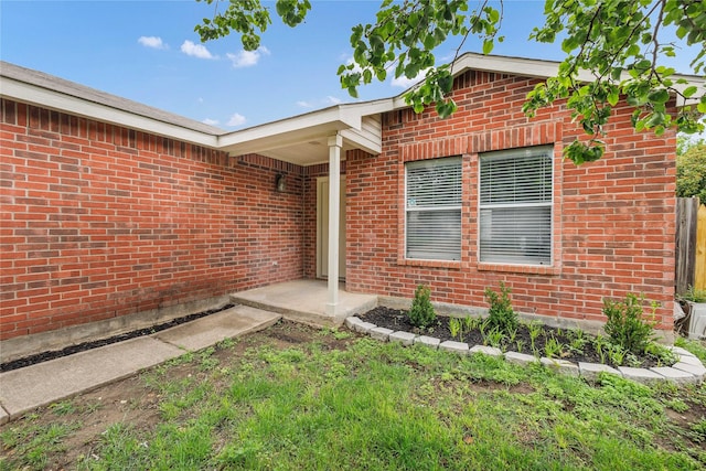 property entrance featuring brick siding