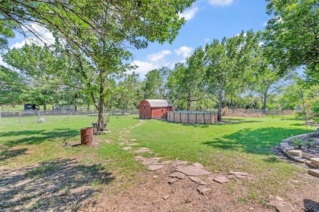 view of yard with a storage shed, an outdoor structure, and a fenced backyard
