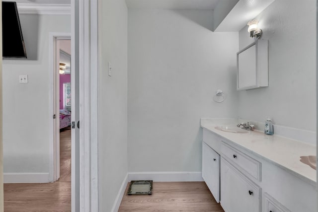 bathroom with baseboards, ensuite bathroom, wood finished floors, and vanity
