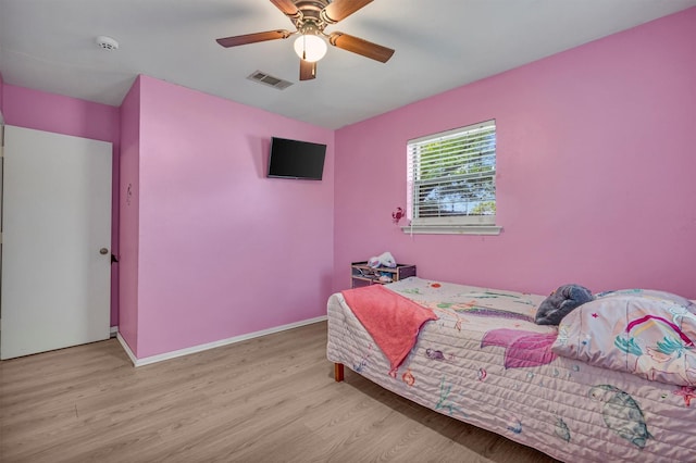 bedroom featuring ceiling fan, visible vents, baseboards, and light wood-type flooring