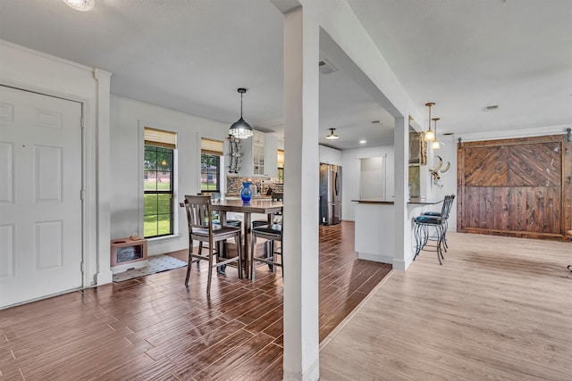 dining room featuring baseboards, visible vents, and wood finished floors