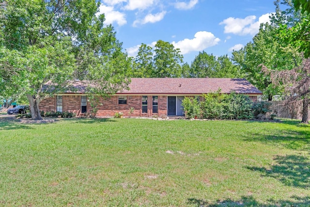 view of front of house with fence, brick siding, and a front yard