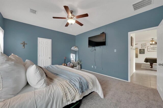 carpeted bedroom with baseboards, visible vents, ceiling fan, and tile patterned flooring