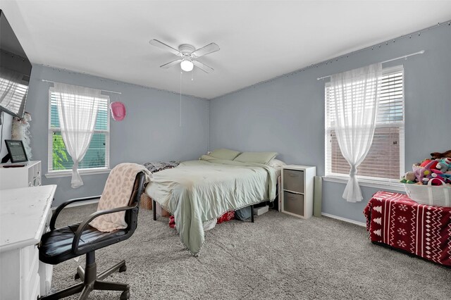 carpeted bedroom with a ceiling fan and baseboards