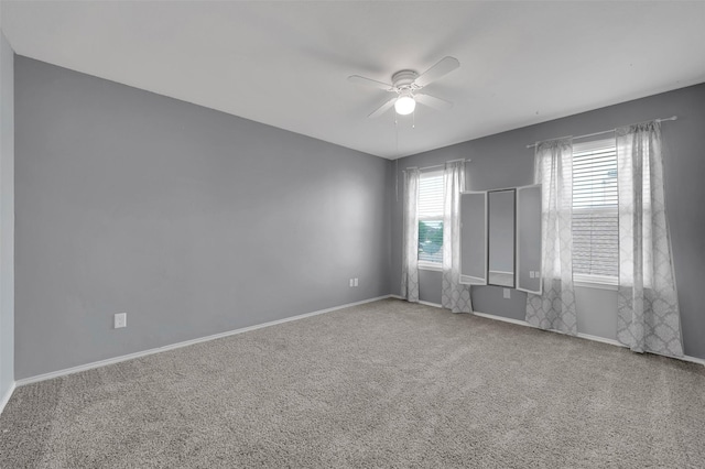 spare room with a ceiling fan, carpet, and baseboards