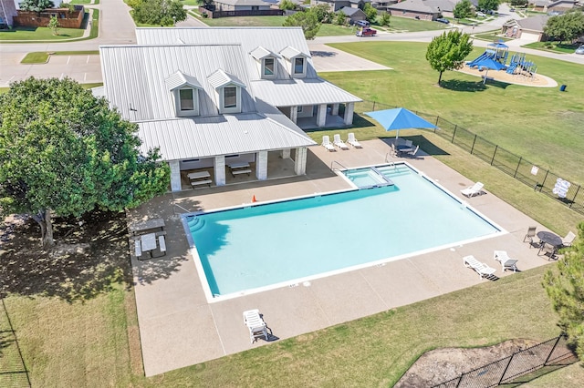 community pool featuring a yard, a patio area, and fence