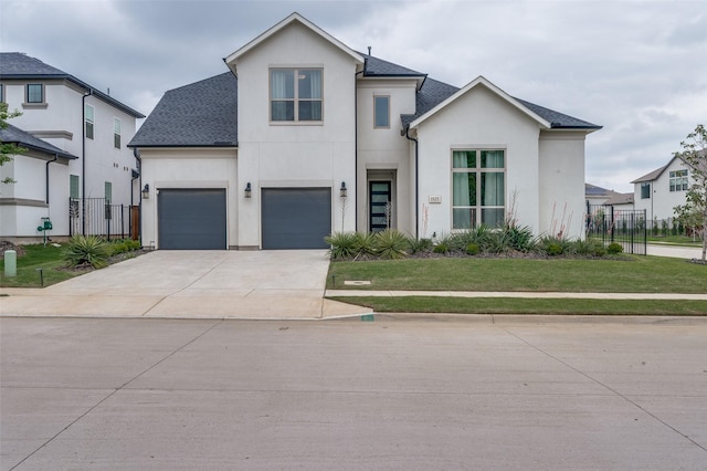 modern farmhouse style home featuring concrete driveway, a front yard, stucco siding, and fence