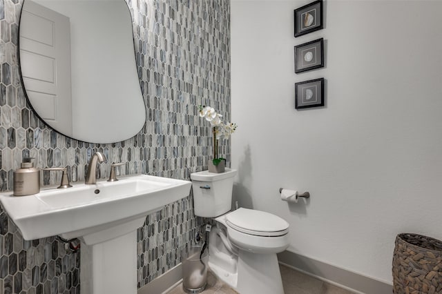 half bathroom featuring baseboards and toilet