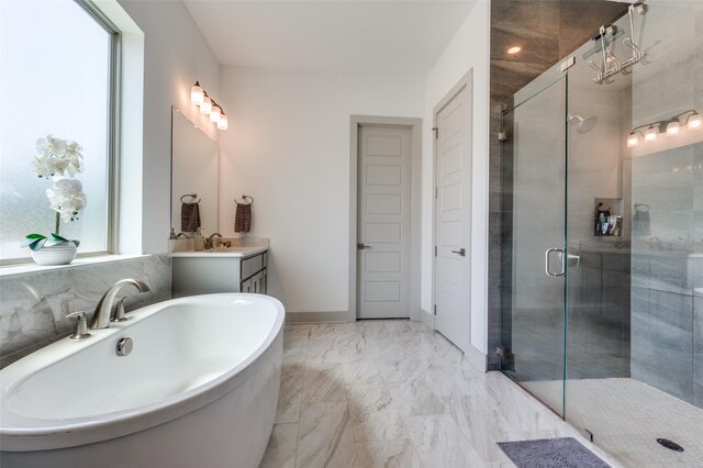 full bath with marble finish floor, vanity, a freestanding bath, and a stall shower