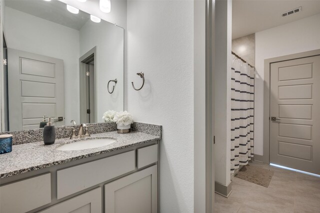bathroom featuring visible vents, a shower with shower curtain, tile patterned flooring, and vanity