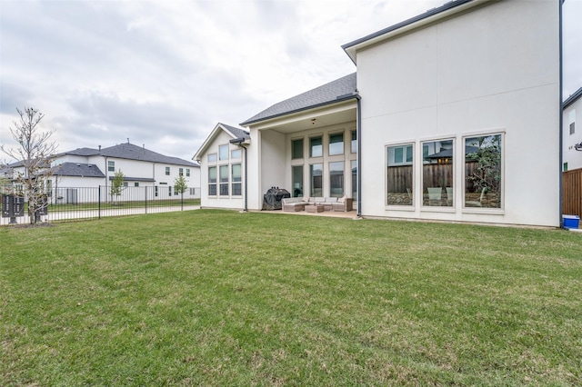 rear view of property featuring a patio, an outdoor living space, fence, and a yard