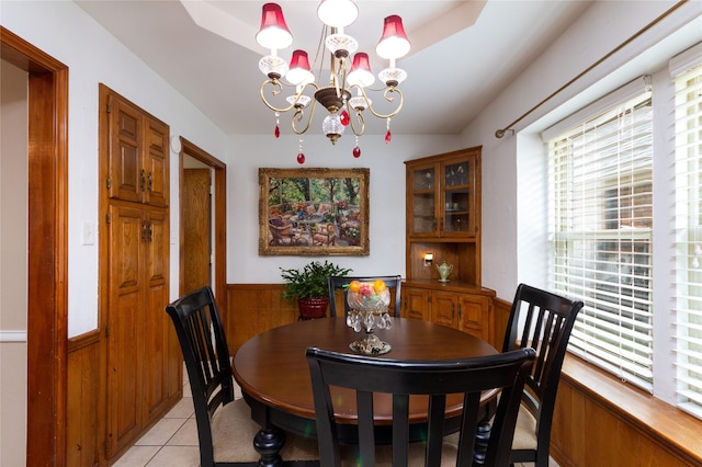 1515 Brighton Dr, Carrollton, TX 75007 - dining space featuring light tile patterned flooring, a wainscoted wall, and a notable chandelier