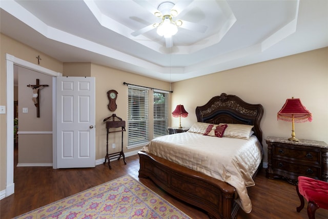 1515 Brighton Dr, Carrollton, TX 75007 - bedroom with wood finished floors, ceiling fan, a tray ceiling, and baseboards