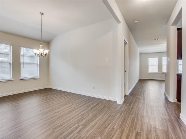 interior space featuring a notable chandelier, wood finished floors, and baseboards