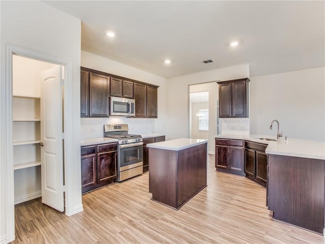 kitchen featuring a sink, visible vents, a peninsula, light countertops, and appliances with stainless steel finishes