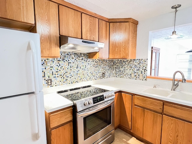 505 N Yosemite, Iowa Park, TX 76367 - kitchen featuring freestanding refrigerator, under cabinet range hood, light countertops, a sink, and stainless steel electric stove
