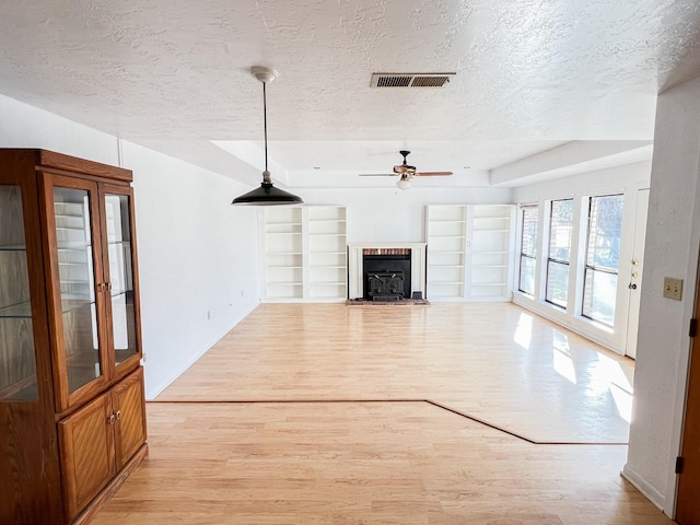 505 N Yosemite, Iowa Park, TX 76367 - unfurnished living room featuring a textured ceiling, visible vents, a ceiling fan, and light wood finished floors