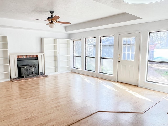505 N Yosemite, Iowa Park, TX 76367 - unfurnished living room with a wood stove, ceiling fan, built in features, and wood finished floors