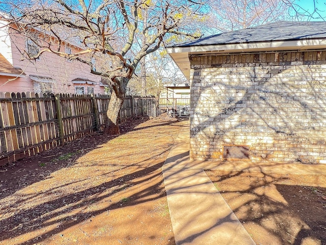 505 N Yosemite, Iowa Park, TX 76367 - view of side of property featuring a patio, fence, and roof with shingles