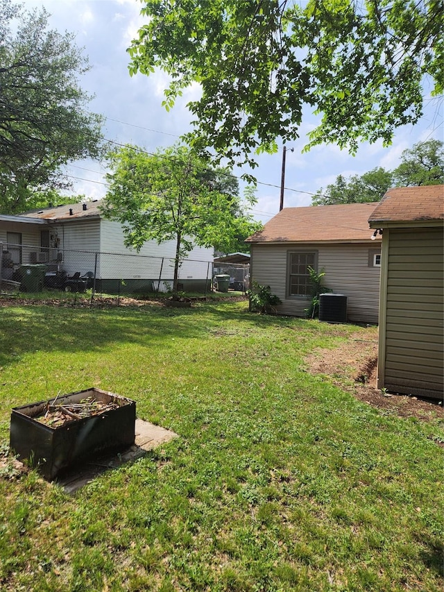 view of yard featuring fence and central air condition unit