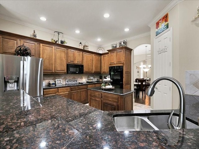 kitchen with arched walkways, brown cabinets, black appliances, ornamental molding, and a sink