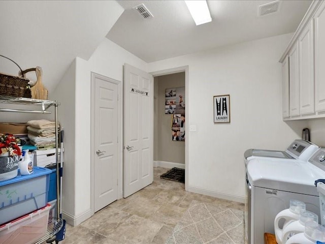 washroom featuring separate washer and dryer, cabinet space, visible vents, and baseboards