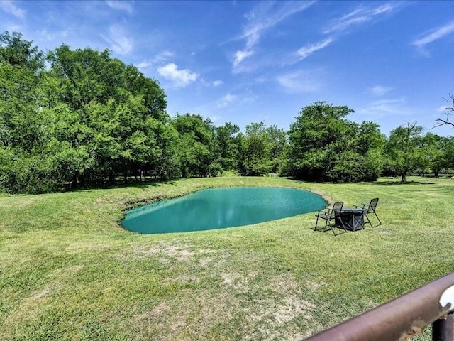 view of pool with a water view and a lawn