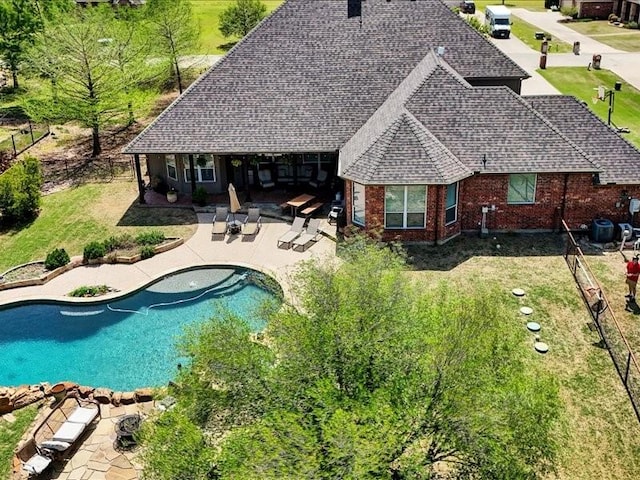 outdoor pool featuring a lawn, fence, and a patio area