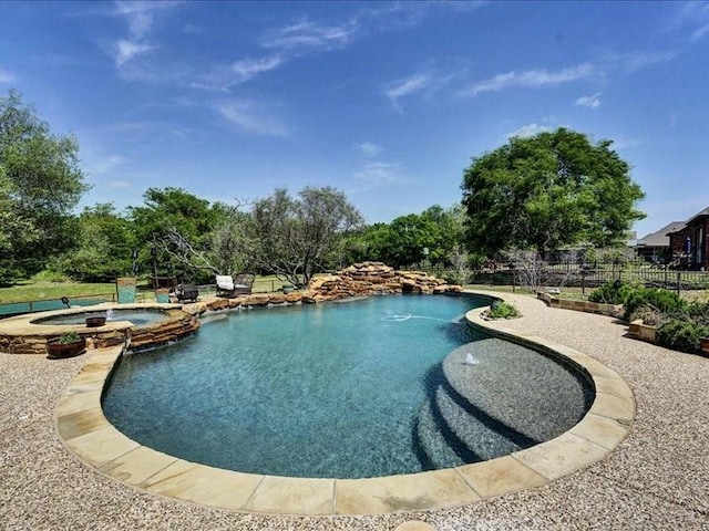 view of pool with a pool with connected hot tub and fence