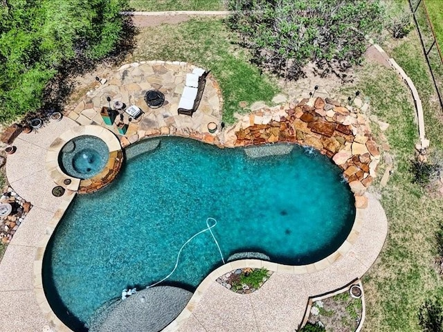 pool with a patio area and an in ground hot tub