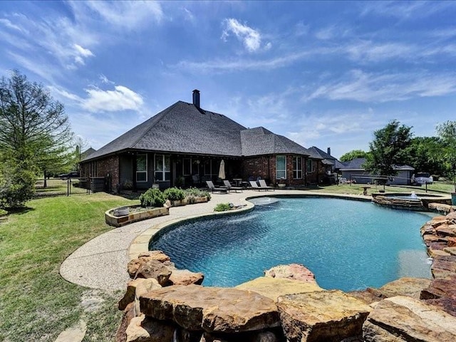view of pool with a pool with connected hot tub, fence, a yard, and a patio area