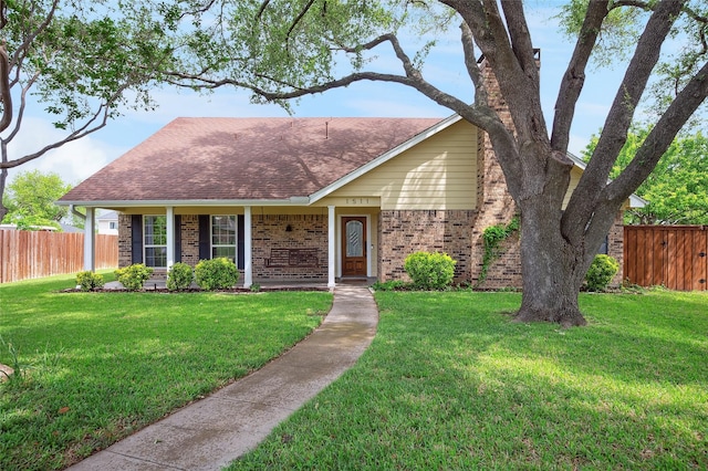 single story home with a porch, brick siding, fence, roof with shingles, and a front lawn