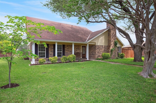 view of front of property with brick siding, fence, and a front lawn