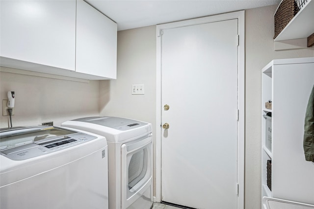 clothes washing area with washer and clothes dryer and cabinet space