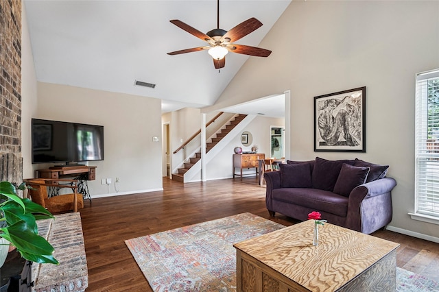 living area with stairs, high vaulted ceiling, a wealth of natural light, and wood finished floors