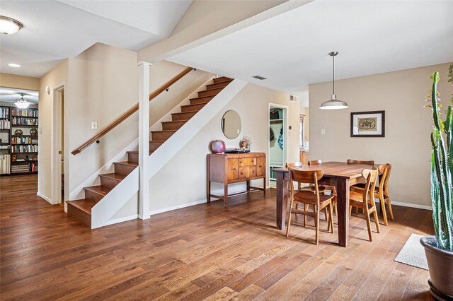 dining room featuring stairway, wood finished floors, visible vents, and baseboards