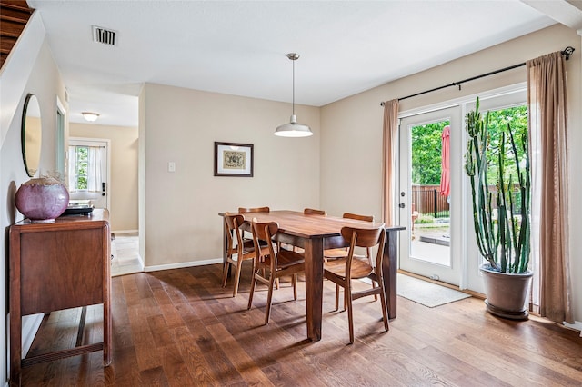 dining room featuring visible vents, wood finished floors, and baseboards