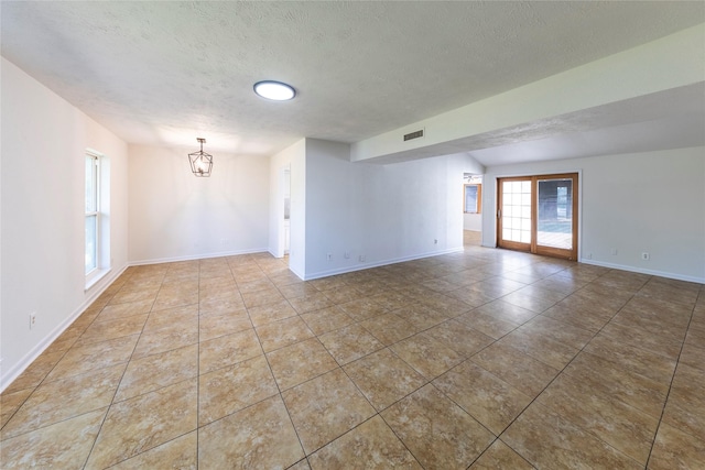 911 Prestwick Ln, Richardson, TX 75080 - tiled empty room with a textured ceiling, visible vents, a chandelier, and baseboards