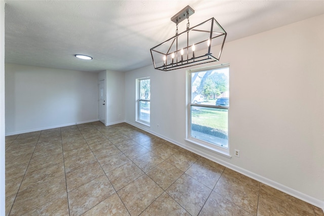 911 Prestwick Ln, Richardson, TX 75080 - unfurnished dining area featuring a notable chandelier, tile patterned flooring, and baseboards